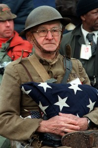 Joseph Ambrose, an 86-year-old World War I veteran, attends the dedication day parade for the Vietnam Veterans Memorial in 1982. He is holding the flag that covered the casket of his son, who was killed in the Korean War.